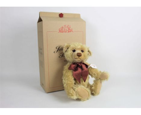 A Steiff limited edition teddy bear, "1999 Millennium", having a blonde mohair covered body, a patterned brown bow, with work