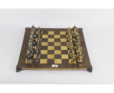 A vintage metal chess board with 32 pieces, measuring 44cm long and wide