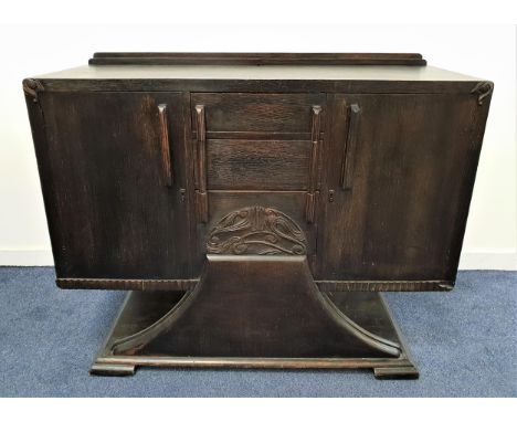 1920s OAK SIDE CABINETwith a raised back above three central drawers, one carved with stylised motifs, and flanked by a pair 