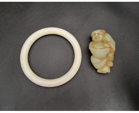 JADE COLOURED HARDSTONE BANGLE and a carved jade coloured hardstone figural pendant 