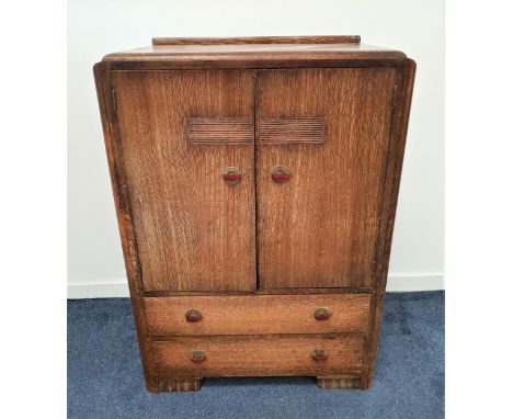 ART DECO LIMED OAK CABINETwith a raised back above a pair of cupboard doors with a shelved interior, above two long drawers, 