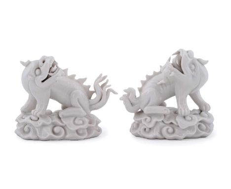 A pair of Chinese 'Blanc de Chine' Buddhist lions, 19th Century, each well modelled on cloud scroll oval bases, 9cms. (2)Note