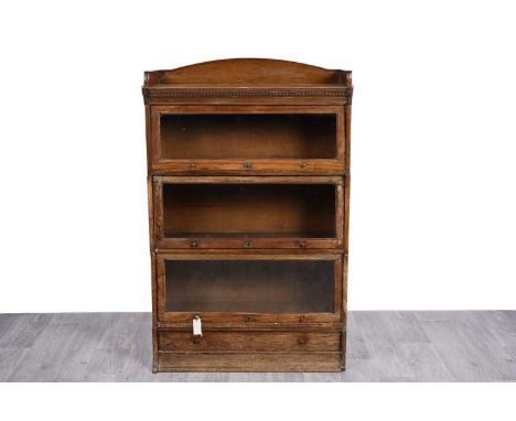 Robsons, Newcastle: an early 20th Century oak sectional barrister ‘The Lebus’ bookcase, with three-quarter gallery above dent