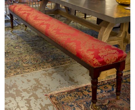 LONG STOOL, part Victorian walnut in red damask on brass castors (adapted) 259cm x 32cm.