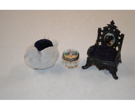 A Victorian spelter pin cushion in the form of an armchair with porcelain panel to the back support, a German bisque pin cush