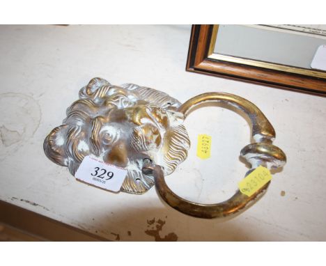 A brass door knocker with lion mask decoration 
