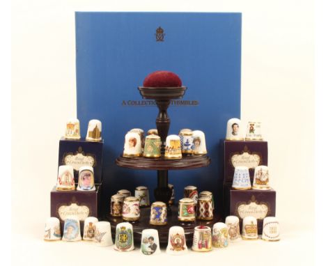 Modern ceramic thimbles, comprising; a set of fifteen by Royal Crown Derby, based on historic patterns on a two tier mahogany