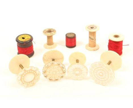 Nine reels and reel holders, comprising; four variant mother of pearl top examples, on brass stems and bone bases, three wood