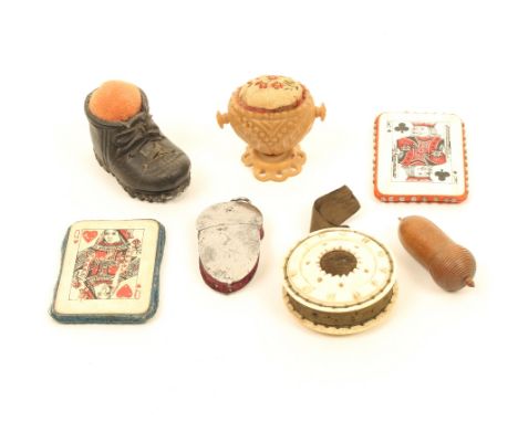 Seven pincushions, comprising; two printed playing card examples, 4.6cm, a turned and carved bone roundel form example, 4cm d