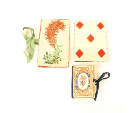 Two  needlebooks and a pin card, comprising; a floral decorated cardboard needlebook in blue and gilt, blue silk spine and ti