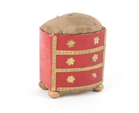 An unusual Georgian pincushion modelled as a bow front chest of three drawers, in red grained morocco paper, with gilt foil d