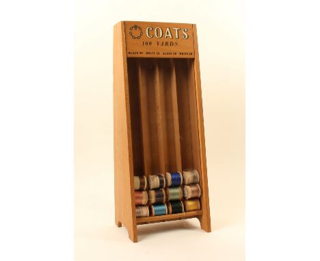 A Coats cotton reel counter display stand, with four reel slots below a panel inscribed "Coats 100 Yards - Black 36 - White 3