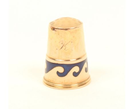 An early 20th century gold thimble, with inset stone top, initialled "K" above a band of blue enamel waves, stamped to the in