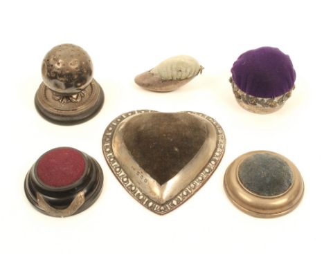 Six silver or silver mounted table pincushions, comprising; a heart shaped example, Birmingham, 1886, 11cm, a ball form examp