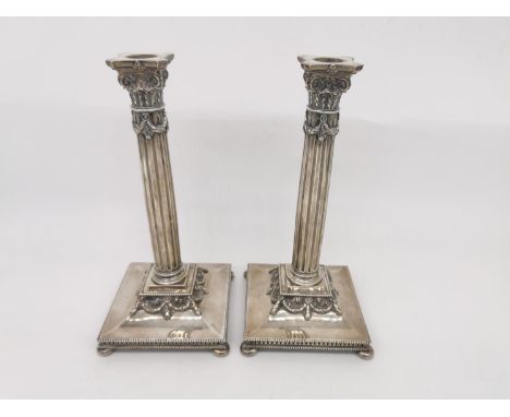 A pair of Dutch silver candlesticks with fluted column design, laurel wreath swag detailing on square bases with pierced gall