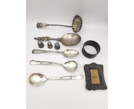 A collection of silver to include silver three thimbles, a ladle, four spoons, a picture frame and, a napkin ring. Silver wei