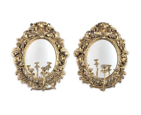 A pair of 19th century giltwood girandolesEach having an oval mirror plate in a moulded surround, the outer frame carved with