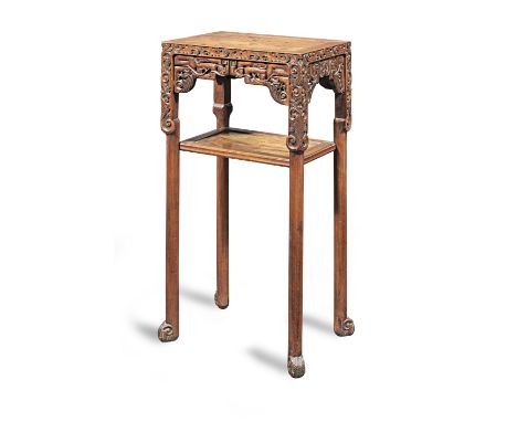 An early 20th century hardwood two-tier stand, ChineseHaving a flush panelled top, and archaistic angular scroll-carved apron