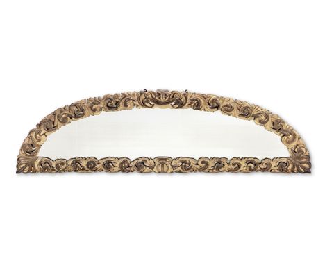 A large 19th century carved giltwood demi-lune overmantle mirrorHaving an acanthus-leaf carved frame, with double-C and swag-