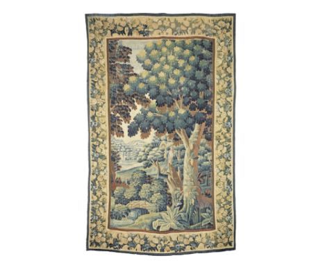 An early 18th century verdure tapestry, FlemishWorked in wool, designed with a colourful bird resting amongst large canopied 