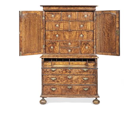 A George II figured-walnut secretaire-cabinet-on-chest, circa 1725Having a cavetto-moulded cornice, a pair of flattened ogee-