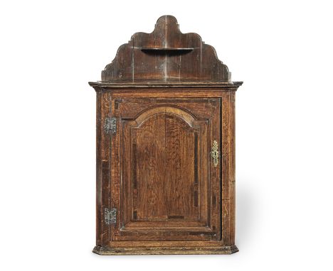 A George II oak, pine and crossbanded mural corner cupboard, circa 1740Having an integral shaped open-shelf superstructure, a