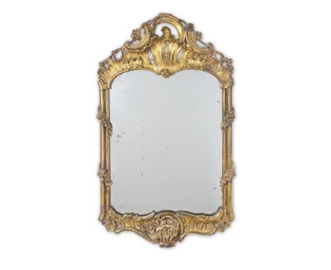 A carved giltwood mirrorMid-18th century, ItalianThe cartouche-shaped frame designed with rockwork, C-scrolls and floral ribb
