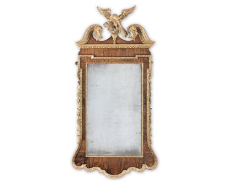 A George II style walnut and parcel-gilt mirrorThe bevelled mirror plate within an inner framing of gilt-gesso, the swan-neck
