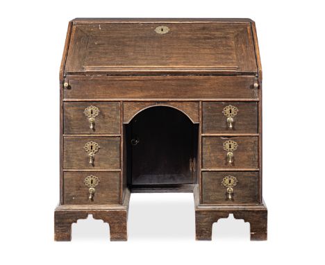 A George II joined oak knee-hole bureau, circa 1750Having a cleated sloping fall with bookrest, enclosing a stepped fitted in