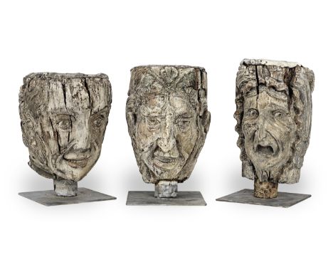Three large carved grotesque heads, probably 17th/18th centuryEach looking straight ahead, with long flowing hair, exaggerate