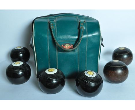 A collection of mid 20th century wooden and plastic bowling balls. The lawn bowls balls being marked up for an Arrow Bowling 
