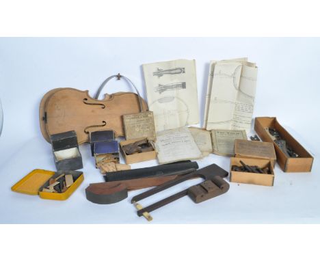 A collection of vintage early 20th century and later violin repair and replacement pieces to include tailpieces, frogs, pegs,