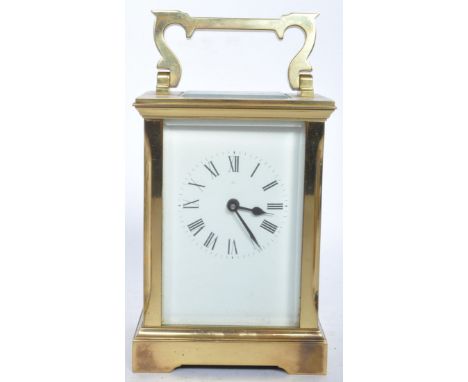 A vintage 20th century Ronson carriage clock having a shaped carry handle to the top, bras and gilt case, white enamel clockf