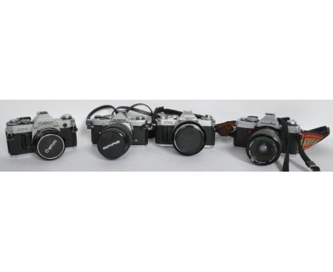 A collection of four vintage 20th century film camera comprising of a Canon AT-1 FD 55mm lens, Canon AV-1 with an Canon 55mm 