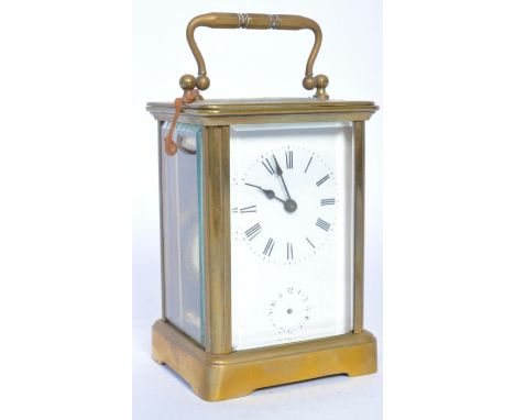 A late 20th century brass carriage clock having a white enamel face, Roman numerals to the chapter ring raised on bracket fee