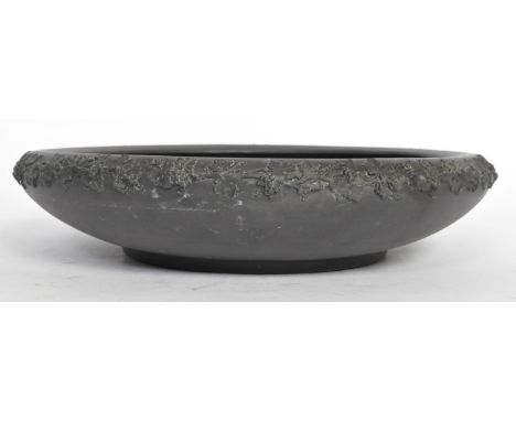 A vintage 20th century Wedgwood Jasperware black basalt bowl having embossed floral decoration in relief to the edge. Makers 