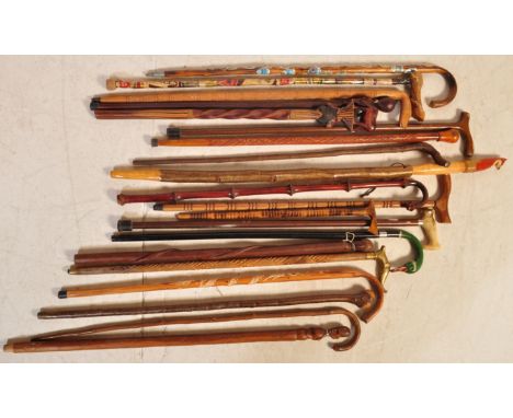 A large collection of vintage 20th century walking sticks and staffs to include souvenir shield examples, carved wood example