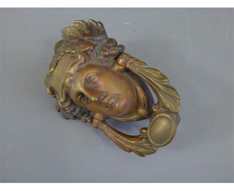 A Brass Door-Knocker, modelled as a classical face, together with a brass circular door-knob and five brass lock plates.