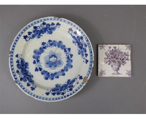 A 19th Century Blue and White Delft Charger, (af) with a Delft tile depicting flowers. (2)