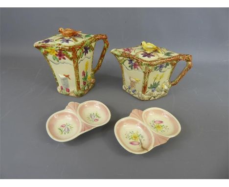 A Pair of Wadeheath Teapots, the teapots with floral and stem designs in relief, the lids bearing the figure of a bird (the b