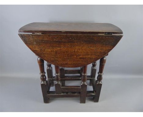 A Small Oval Drop Leaf Table on turned gate legs, approx 72 x 65 x 63&nbsp; cms.&nbsp;