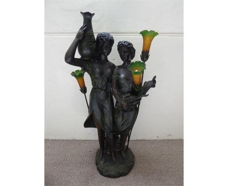 An Art Nouveau Style Spelter Floor Lamp. The lamp in the form of  two maidens, one holding a vase decorated with roses, the o