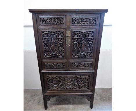 A Chinese Teak Cabinet, with double doors that open to reveal a fitted shelved interior, the lower shelf benefits from a draw