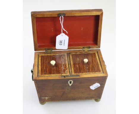 An early 19th century mahogany boxwood crossbanded and strung tea canister of sarcophagus form, the hinged lid enclosing a tw