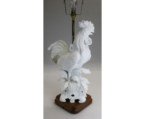 A white glazed pottery figural cockerel table lamp, in the style of the Meissen blanc de chine menagerie figures, mounted on 