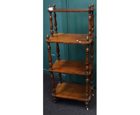 An Edwardian walnut four tier whatnot, with baluster ring turned supports, on ceramic castors, 136cm