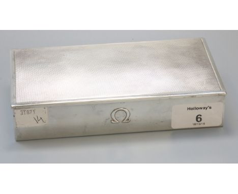 A Swiss white metal 'Omega' box, rectangular with engine turned hinged cover, the front embossed with the Omega symbol, marke