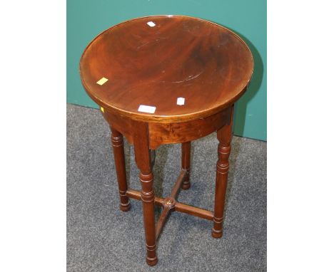 An Edwardian mahogany lamp table, the circular dished top on ring turned tapering legs united by an 'X' stretcher, bears bras