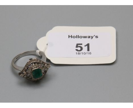 An emerald and diamond cluster ring, the central cut cornered step cut emerald in raised rub-over mount, above graduated open
