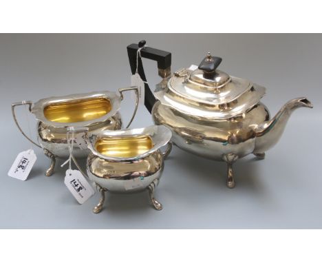 Walker and Hall, a silver three piece tea service, comprising pot, twin handled sugar and cream, each on four scallop cast fe